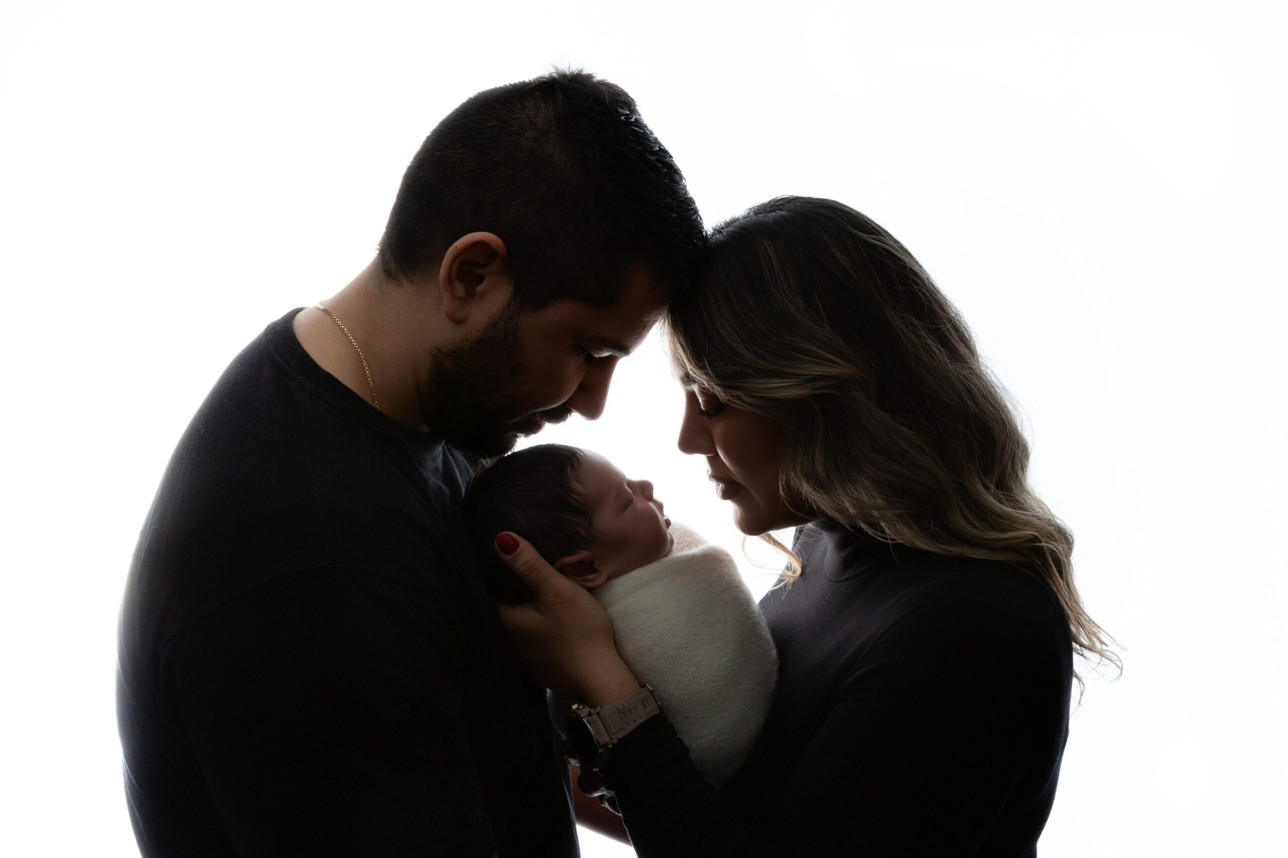 Newborn baby with parents photographed in studio by a West Island newborn photography specialist